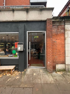 Glass door with silver frame. Push from left to open. Built in ramp leading up to door.