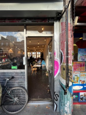 Glass door with grey frame. Push from left to open.