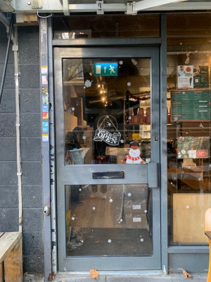 Glass door with metal frame. Push door to open from metal handle on right.