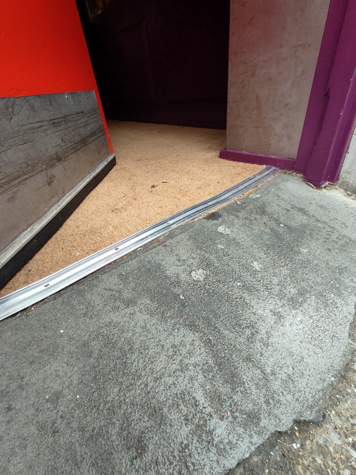 Built-in ramp before door. Small bump on threshold of door followed by doormat.