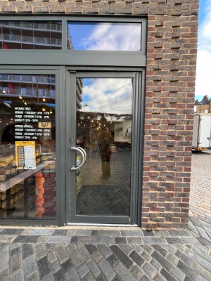 Glass door with grey frame. Push silver handle from right to open.