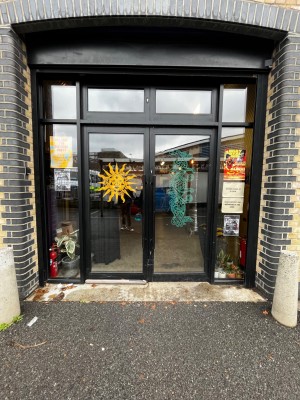 Glass double doors with black frame. Push from middle to open.