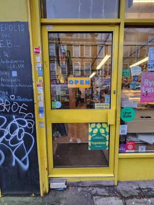 Glass door with yellow frame. Push from right to open