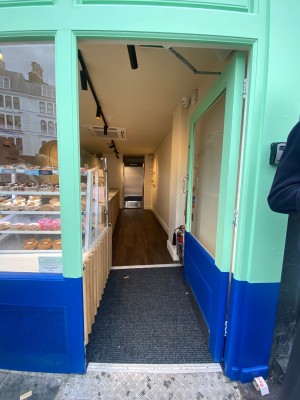 Glass door, with light blue doorframe. Silver handle on left. Push to open.