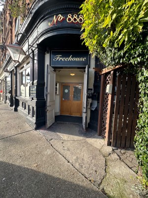 From street facing main entrance. Entrance to outdoor area to right. Main entrance is through two sets of double doors.
