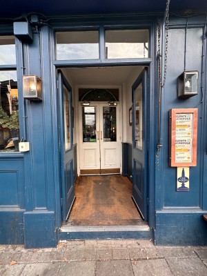 Glass doors with blue wooden frames ahead. Push from center to open.