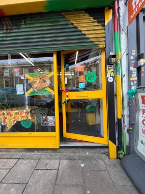 Manual glass door outlined in yellow straight ahead. Push from left to open.