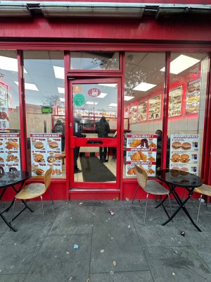 1 step followed by single glass door with handle on the left. Push to open.