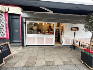 From street facing straight. Counter straight ahead to the left. Staff door ahead. Outdoor area on right side.