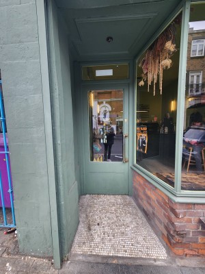 From street, facing venue. Opening ahead to door at back.