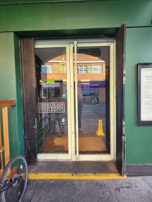 Glass door with white frame. Pull white handle in middle to open.