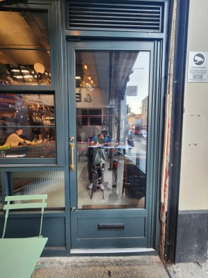 Teal bordered door. Handle on left. Push to open.