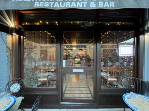 Entrance straight. Single glass door outlined in brown wood. Push from left to open.