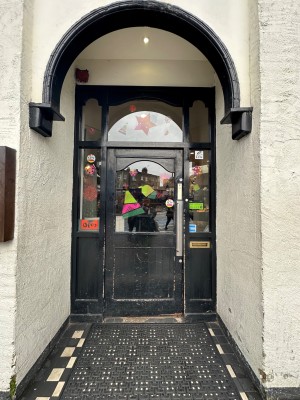 From street, facing venue. Archway ahead. Doorway behind.