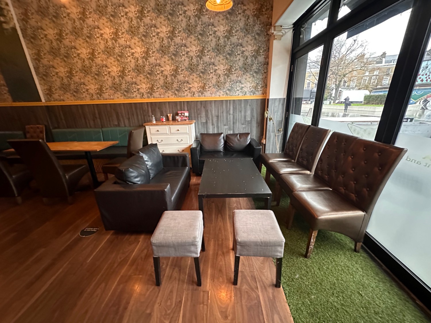 From entrance looking right. Couch, armchairs, and stools ahead.