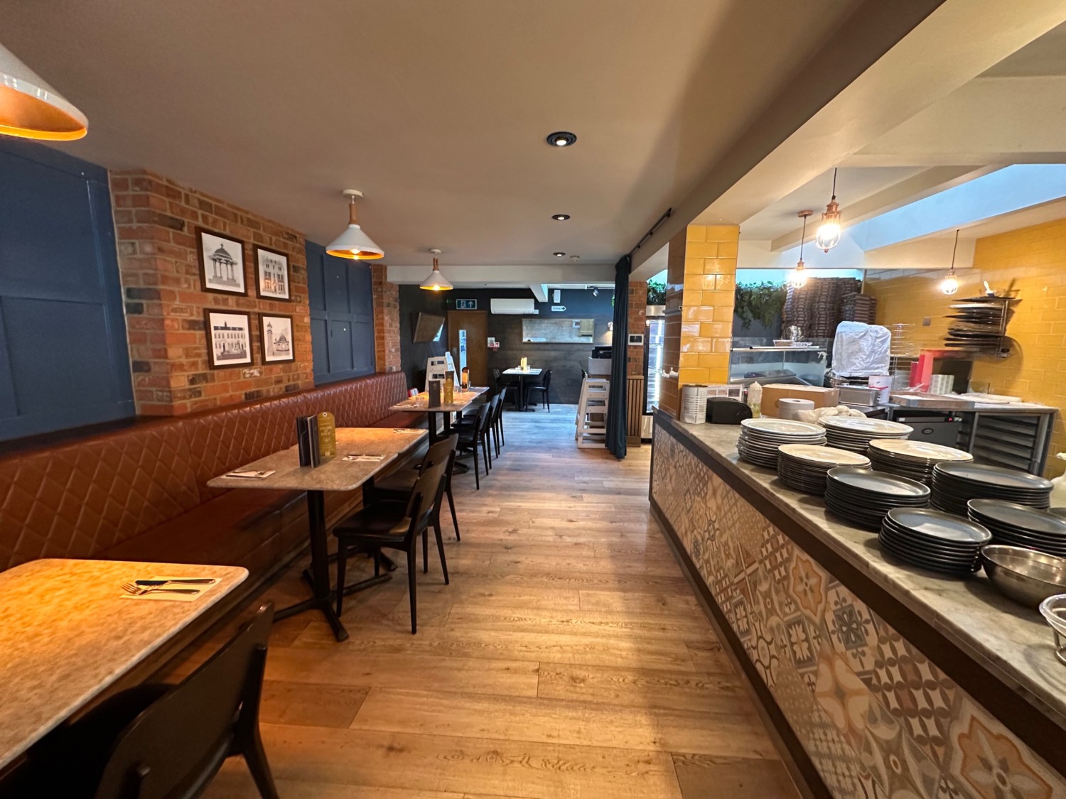 From start of open kitchen facing straight. Half booths along left. Open kitchen along right.