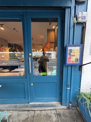 Glass door with blue frames. Push from left handle to open.