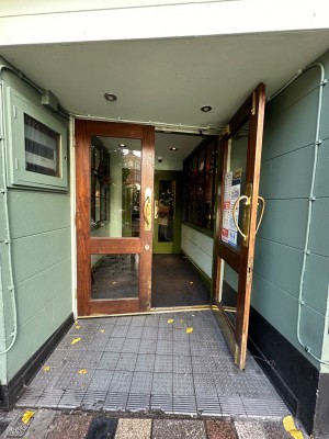 Opening ahead to glass doors with wooden frame in back. Pull doors to open via brass handles in center.