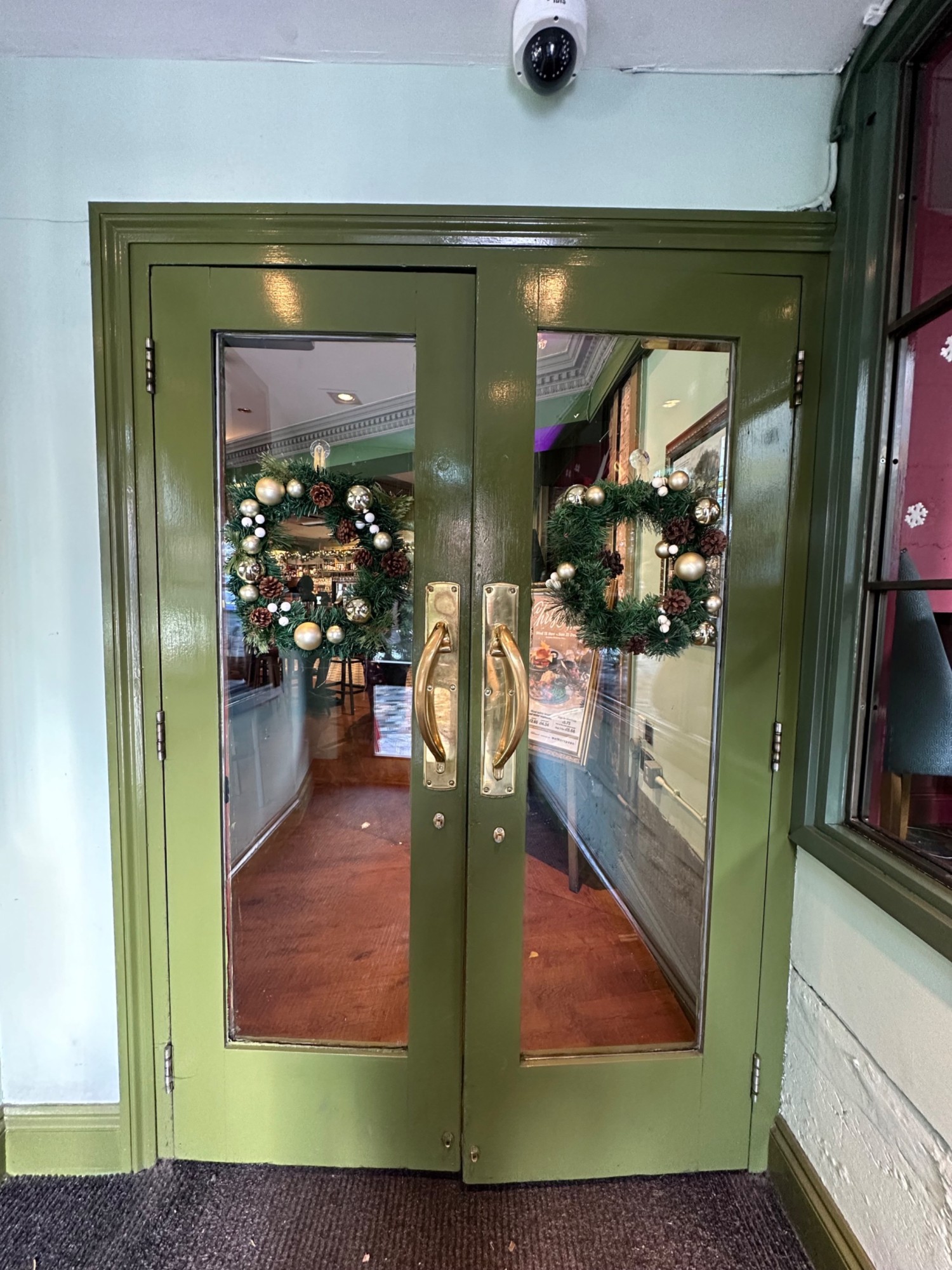 From first set of doors facing straight. Second set of glass doors with green frame ahead. Pull from centre to open.