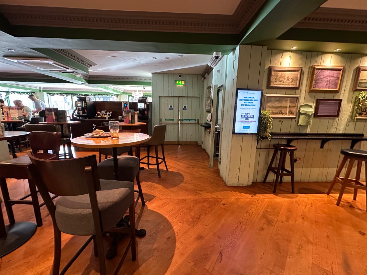 From end of path facing left. High tables and stools seating along left and right. Bathroom on back right.