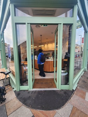 Glass doors with green frame. Push black handles in centre to open.