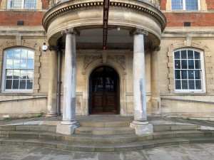 Four steps up through open archway before door.