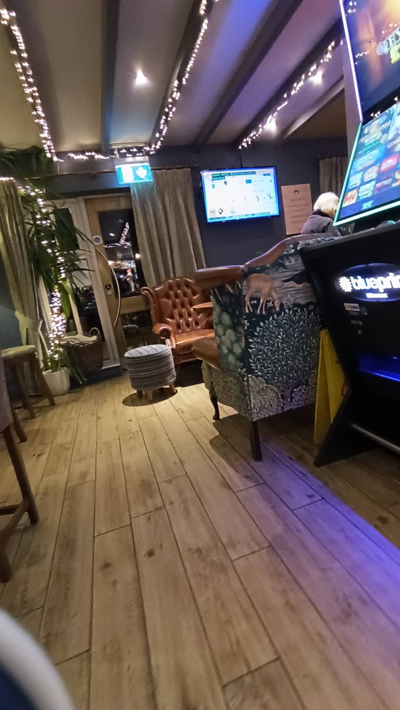 Area next to bar for bar snacks and drinks. Large arm chairs, wooden flooring, high bar table with bar stools
