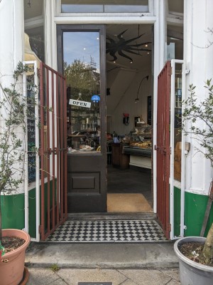 One step up to red gate with white frame. Push from centre to open.
