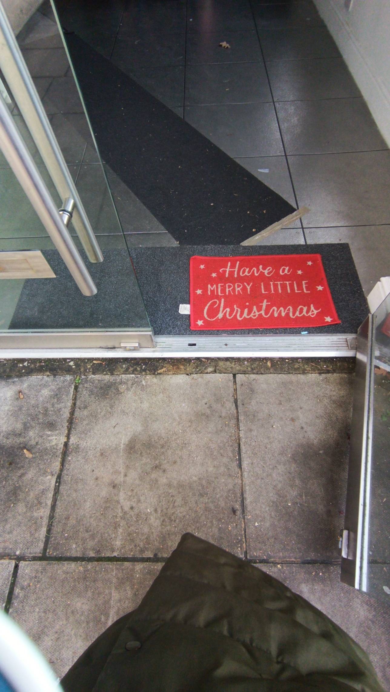 Two glass front doors, opening outward from middle, small raised threshold strip approx 2-3cm height. Paved outside going into tiled floor inside
