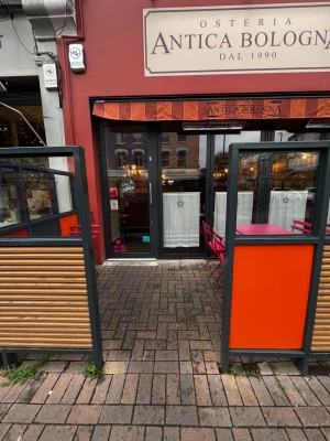 From street, facing venue. Opening ahead to doorway at back.