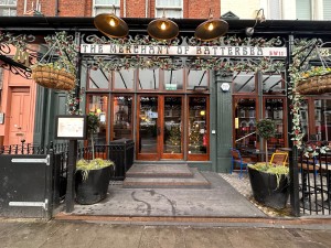 Facing main entrance from street. Doors straight ahead, outdoor seating area to right.