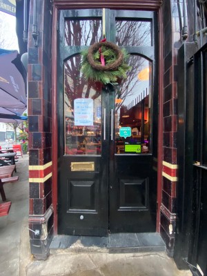 Glass doors with black frames. Pull from handles in centre to open.