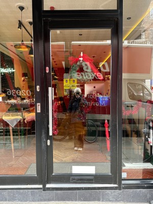 One step up to glass door with black doorframe. Push from left to open
