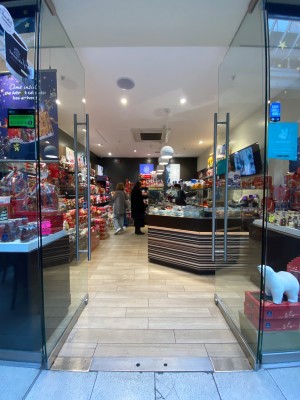 Glass doors with silver metal handles in middle. Push to open.