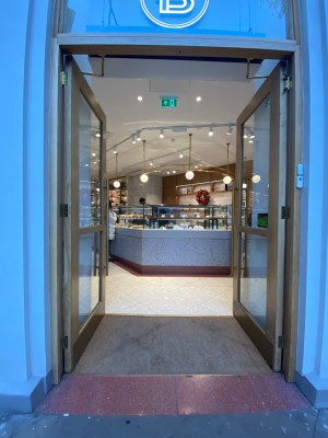 Glass doors with golden metal frame. Push silver handles in middle to open.