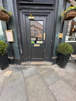 Glass door with dark green frame. Pull golden handle on right to open.