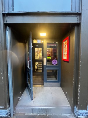 One step up to blue framed glass doors. Pull from centre to open.