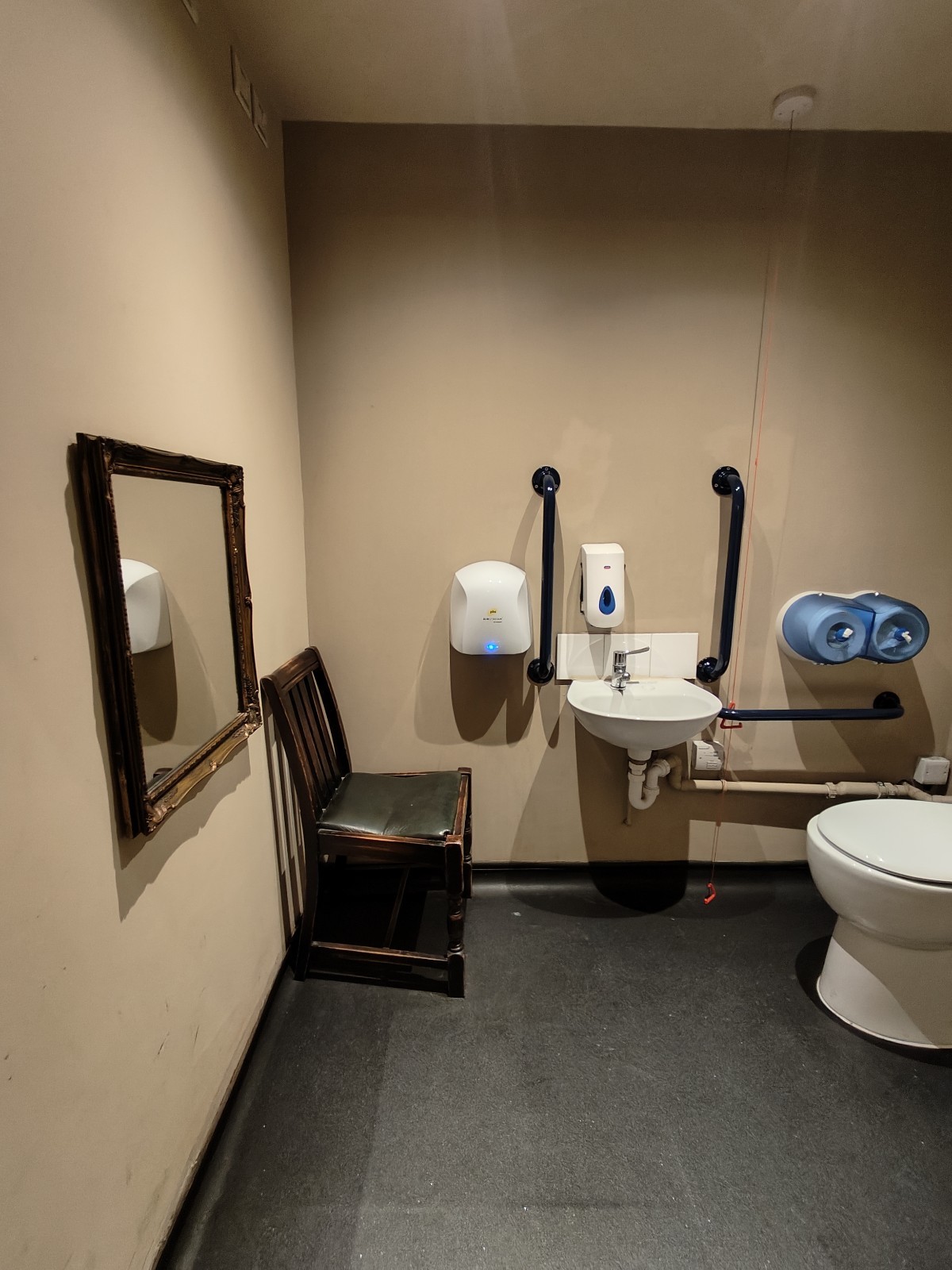 From door facing straight. Chair on left. Sink at back wall.