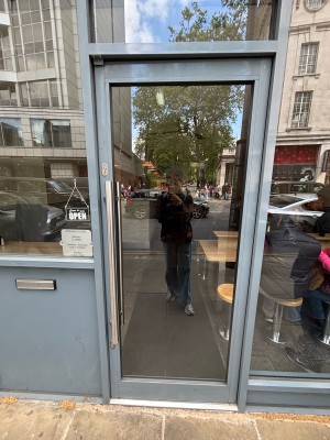 Glass door with blue frames. Push from left handle to open.