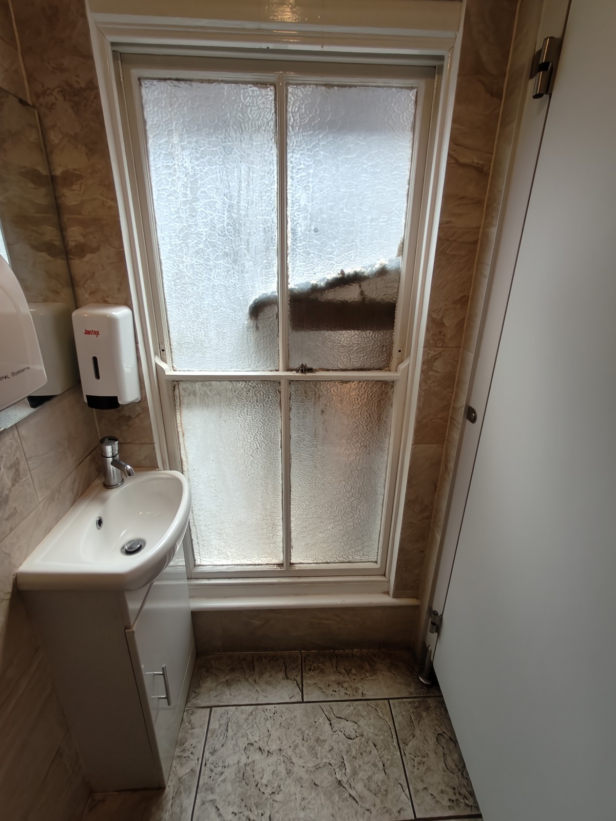 From second preceding door facing straight. Sink on left. Toilet cubicle on right.