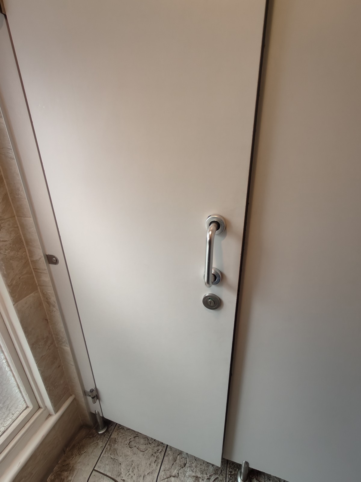 From sink facing right. White toilet door ahead. Pull silver handle on right to open.