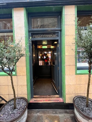 Glass door with grey wooden frame. Push from left to open.