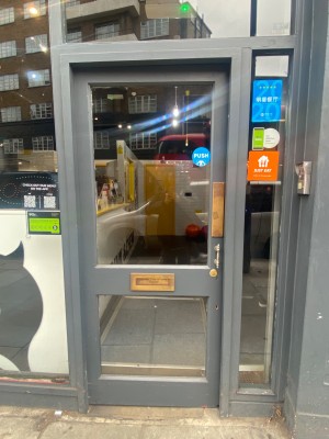 Grey single door with glass panels. Push from right to open.
