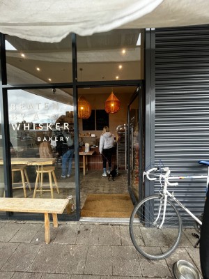 Glass door with black, metal frame. Push silver handle on left to open.