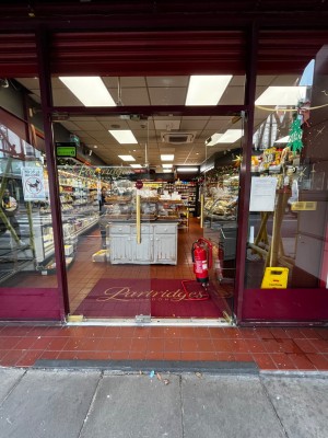Glass doors with red frame. Push handle in centre to open.
