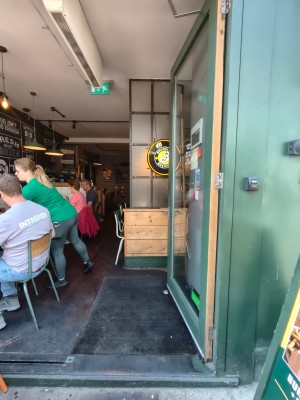 Glass door with wooden frame ahead. Push from handle on right to open