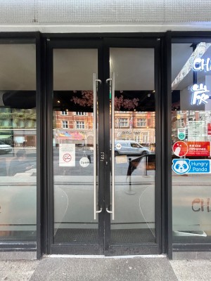 Double glass doors with black frame. Pull handle from middle to open.