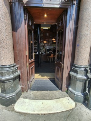Brown framed glass doors. Push from centre to open.