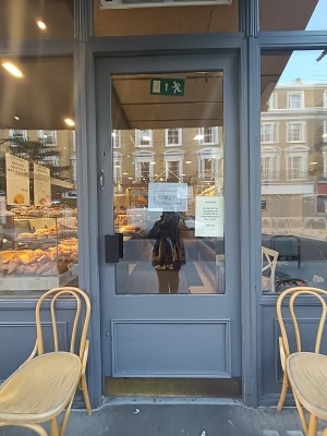 Glass door with grey, wooden frame. Push black handle on left to open.