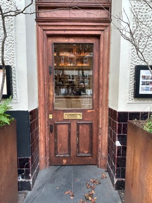 Single wooden door with glass panel. Push from left to open.